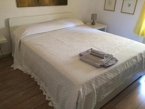 卡斯拉諾的住宿－Mansarda Caslano，一张白色的床,上面有一条毛巾