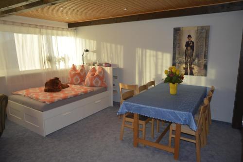 Familienzimmer Bastian في Haibach: غرفة نوم بسرير وطاولة مع كراسي