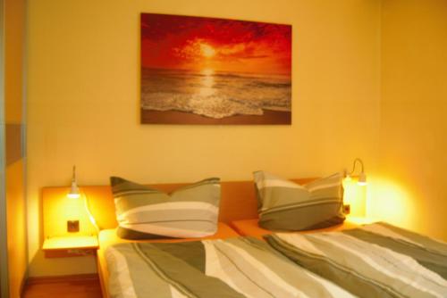 a bedroom with a bed with two pillows and a painting at Ferienwohnung an der Brockenbahn in Wernigerode