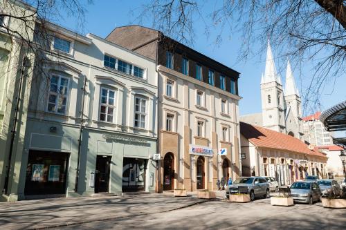 a city street with buildings and a church at Hotel Forum Garni in Subotica