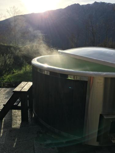 a bath tub sitting next to a wooden bench at Bellissimo Rustico A 7 km Dal Lago D'Orta in Omegna