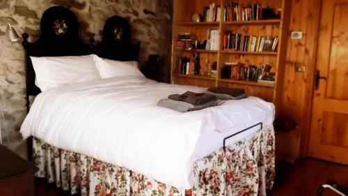 a bedroom with a large bed with white sheets at Bellissimo Rustico A 7 km Dal Lago D'Orta in Omegna