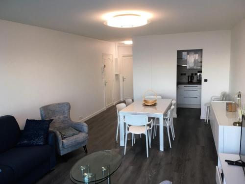 un salon avec un canapé, une table et des chaises dans l'établissement SPLENDIDE T3 DE 70m2 VUE MER A 2 MINUTES DU CENTRE-VILLE, à Le Touquet-Paris-Plage