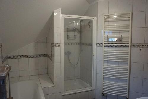 La salle de bains est pourvue d'une douche et d'une baignoire. dans l'établissement Haus Rodriguez, à Baesweiler