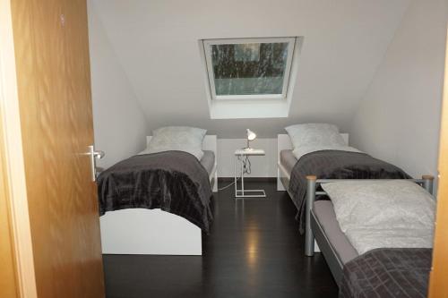 a room with two beds and a table with a window at Haus Rodriguez in Baesweiler