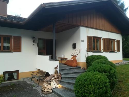 a house with a deer sitting on the stairs at Montafon Alpen Chalet in Vandans