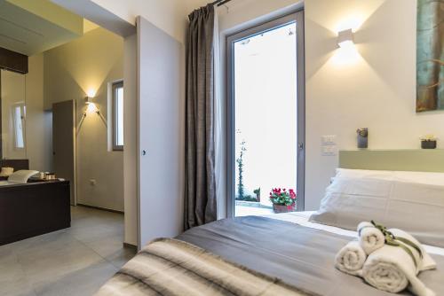 a bedroom with a bed and a large window at Elle Suite in Lecce