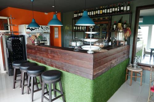 un bar con taburetes en la parte delantera de un restaurante en ibeyond Apartment Romklao Suvarnabhumi en Lat Krabang