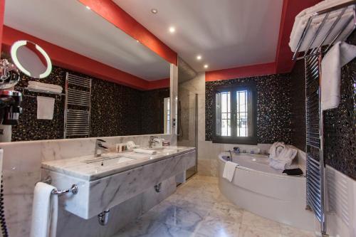a bathroom with a large tub and a large sink and a bath tub at Pintor El Greco in Toledo