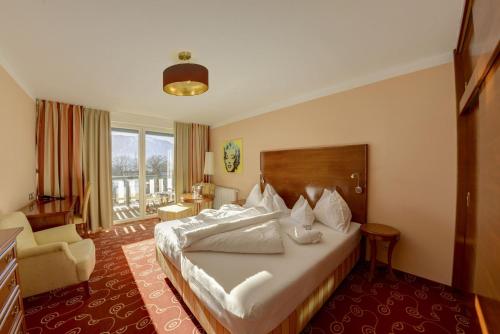 um quarto de hotel com uma cama e uma cadeira em Das Moerisch em Seeboden