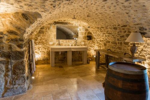 una sala de cata de vinos con un fregadero en una pared de piedra en Les Hiboux du Domaine du Moulin, en Étables