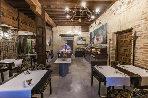 a restaurant with tables and chairs in a room at Pintor El Greco in Toledo