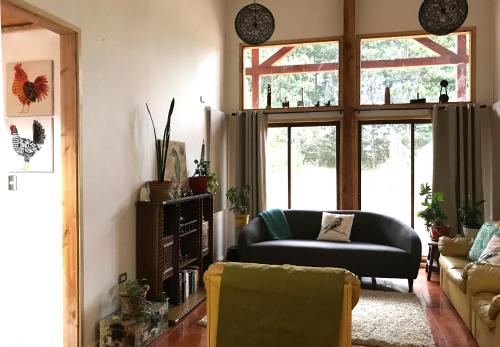 a living room with a couch and a chair at Hostel Isla del Rey in Valdivia