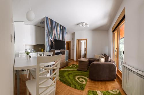 a living room with a kitchen and a dining room at Central point Zlatibor in Zlatibor