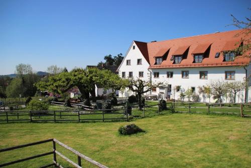 a large white house with a fence in a field at Hotel Montfort-Schlössle in Lindau