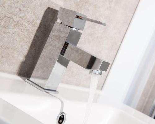 a water faucet in a bathroom with a sink at The Globe Angle in Pembrokeshire