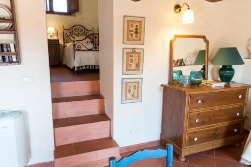 a room with a staircase and a mirror and a dresser at Borgo Solamore in Cortona