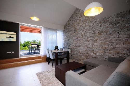 a living room with a couch and a brick wall at Pálavské Apartmány in Pavlov