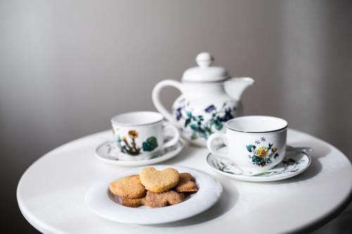 una mesa con tres tazas de té y galletas en un plato en Agriturismo Cà del Nono, en San Marzano Oliveto