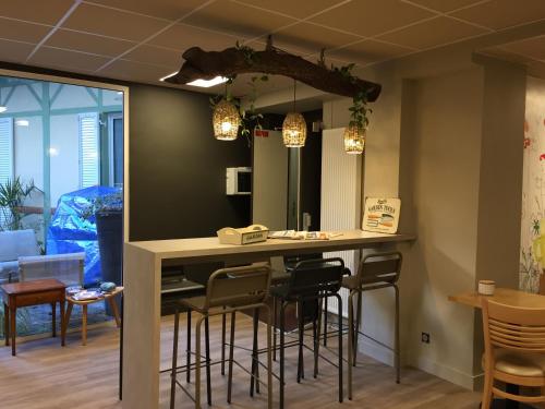 a kitchen with a bar with stools at Garden Apparts Rennes Centre Gare in Rennes