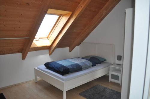 sypialnia z łóżkiem i drewnianym sufitem w obiekcie Ruhige Wohnung bei München, Fürstenfeldbruck, Dachau w mieście Oberschweinbach