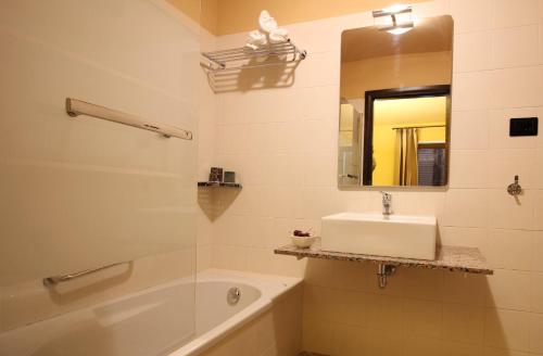 a bathroom with a sink and a tub and a mirror at Villa Brettino- Pesaro mare e cultura - intera struttura con piscina in Fano