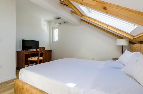 a bedroom with a large white bed and a desk at Superior apartment Nike in Mlini