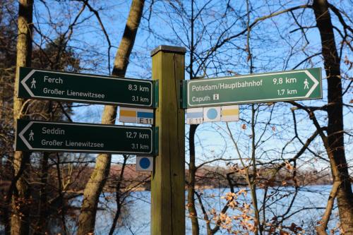 a pole with street signs in front of a river at Ferienhaus Caputh in Caputh