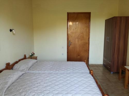 a bedroom with a bed and a wooden door at Tony studio & apartments in Laganas
