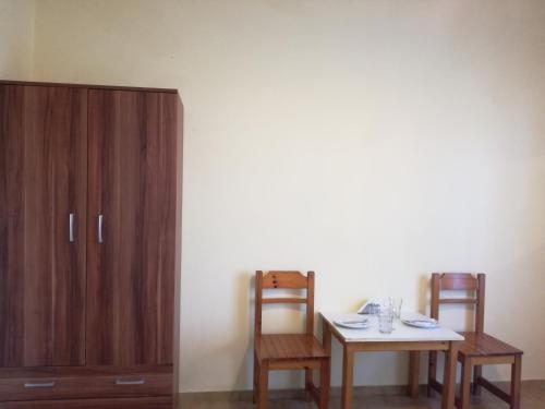 a dining room with a table and two chairs and a cabinet at Tony studio & apartments in Laganas