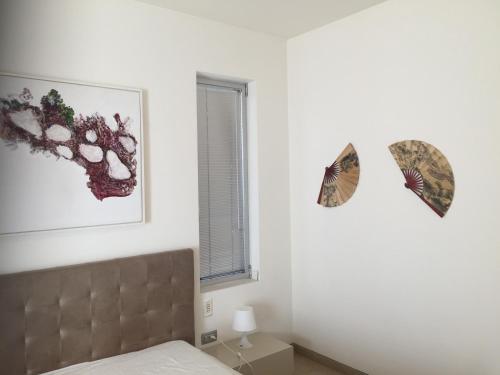 a bedroom with a bed and two butterflies on the wall at Villa Alice Caesarea in Caesarea