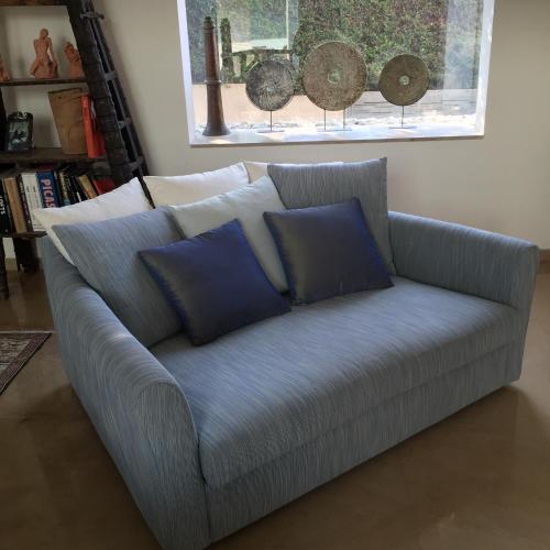 a couch with blue pillows in a living room at Villa Alice Caesarea in Caesarea