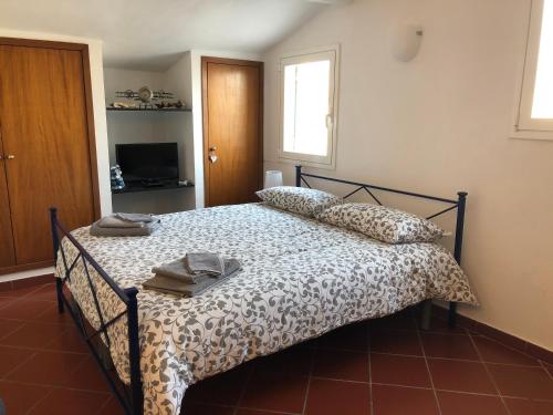 1 dormitorio con cama con edredón y almohadas en La Casa di Dory, en Génova