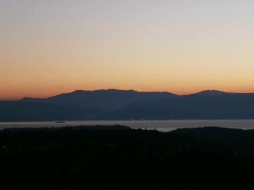 a sunset over a body of water with mountains at Quality Suite, Tranquility, Sea Views, Breeze in Agios Gordios