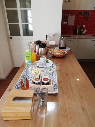 a kitchen counter with a table with food on it at A Bica Hostel in Ponta Delgada