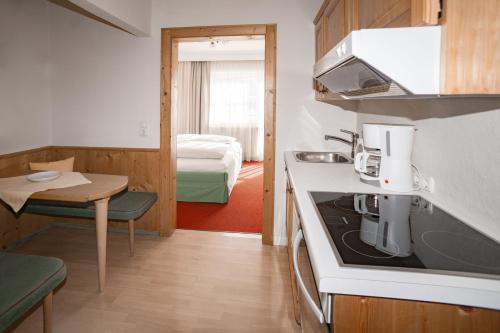 kuchnia ze zlewem i kuchenką górny piekarnik w obiekcie Appartement Erwin & Eleonore Hüttl w mieście Neukirchen am Großvenediger