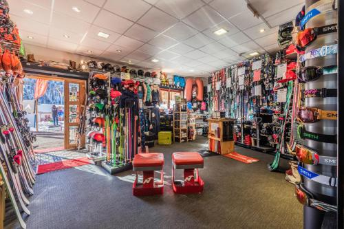 a ski shop with two stools in a room with skis at Anova Hotel & Spa in Montgenèvre