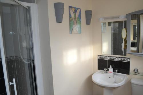 y baño blanco con lavabo y ducha. en Sunnycroft en Sutton on Sea
