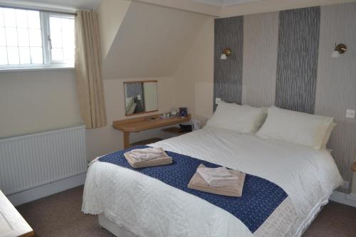 ein Schlafzimmer mit einem Bett mit zwei Handtüchern darauf in der Unterkunft Sunnycroft in Sutton on Sea