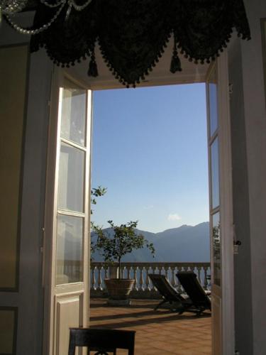 an open door with a view of a balcony with chairs at Villa Colletto in Coreglia Antelminelli