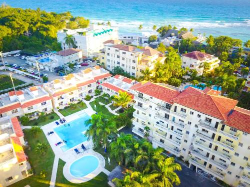 an aerial view of a resort with a pool and the ocean at Las Palmeras by Graziano in Boca Chica