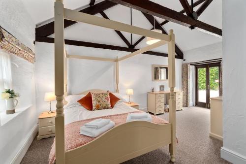 ein Schlafzimmer mit einem Himmelbett in einem Zimmer in der Unterkunft Mill Cottage in Paignton