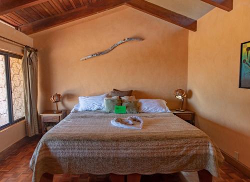a bedroom with a bed with a branch on the wall at Villa Mango B&B in Nosara