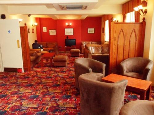 a lobby with chairs and a waiting room with a tv at Three Queens Hotel in Burton upon Trent