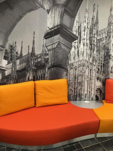 a couch in front of a mural of a castle at AHD Rooms in Milan