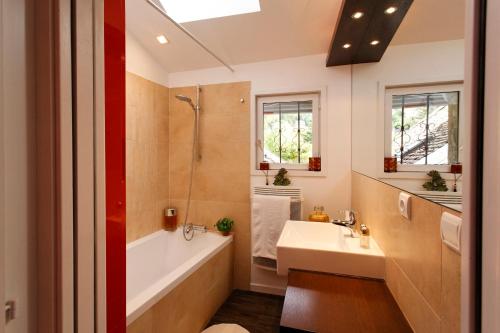 une salle de bain avec une baignoire blanche et un lavabo dans l'établissement Studio La Savoyarde - Vision Luxe, à Menthon-Saint-Bernard