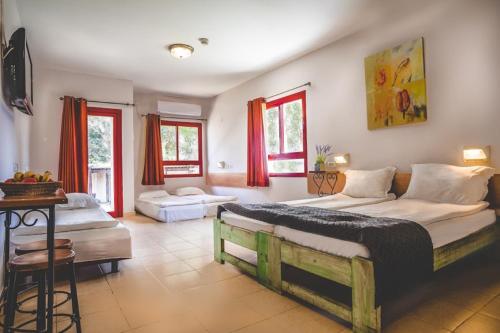 a large bedroom with two beds and a table at Mashabei Sade Kibbutz Country Lodging in Mashabbe Sade