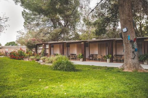 a building with tables and chairs in a yard at Mashabei Sade Kibbutz Country Lodging in Mashabbe Sade