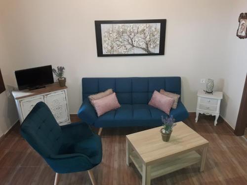 salon z niebieską kanapą i stołem w obiekcie Dimitra's Garden Villa w mieście Kallirákhi