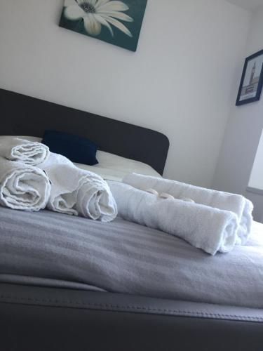 Una cama con toallas blancas encima. en Sama's Stylish Hotel Room 4 en Mánchester